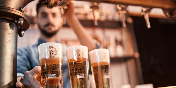 camarero sirviendo cervezas de un grifo